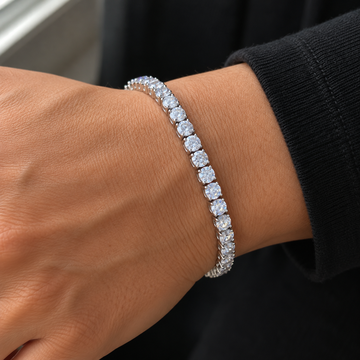 Ice03 Luxury Zirconia Braceletの着用イメージ。黒い袖の手首にシルバーカラーのテニスブレスレット